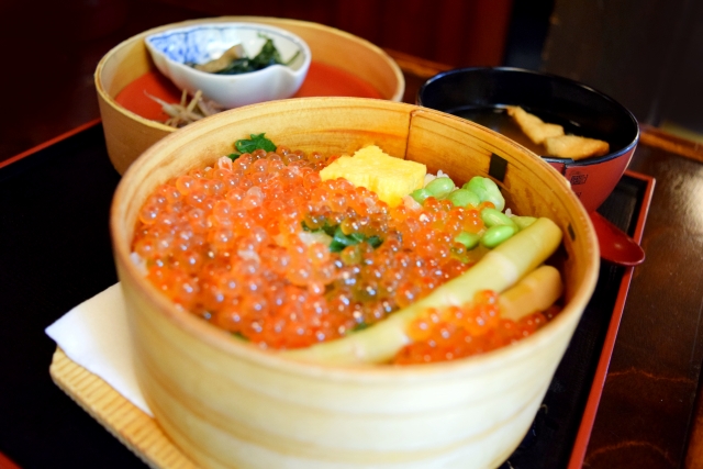 A piping-hot wappa-meshi rice dish loaded with mountain bounty in a wooden vessel