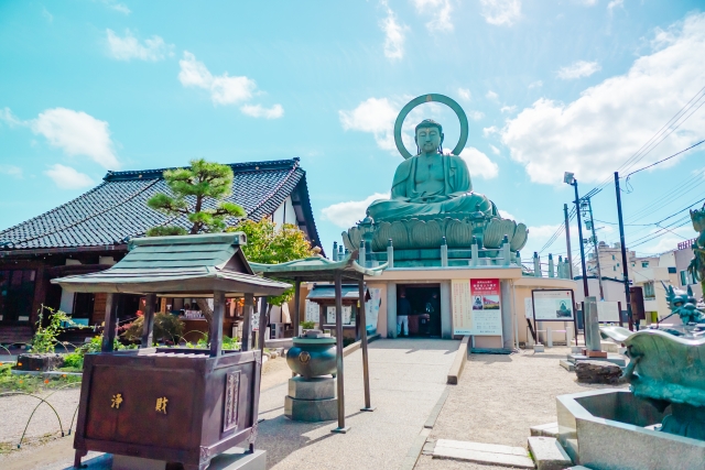 The massive bronze Takaoka Daibutsu against a blue sky