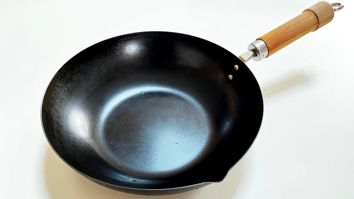 Well-seasoned Japanese iron frying pan showing the dark, glossy polymerized oil surface that builds up through regular use