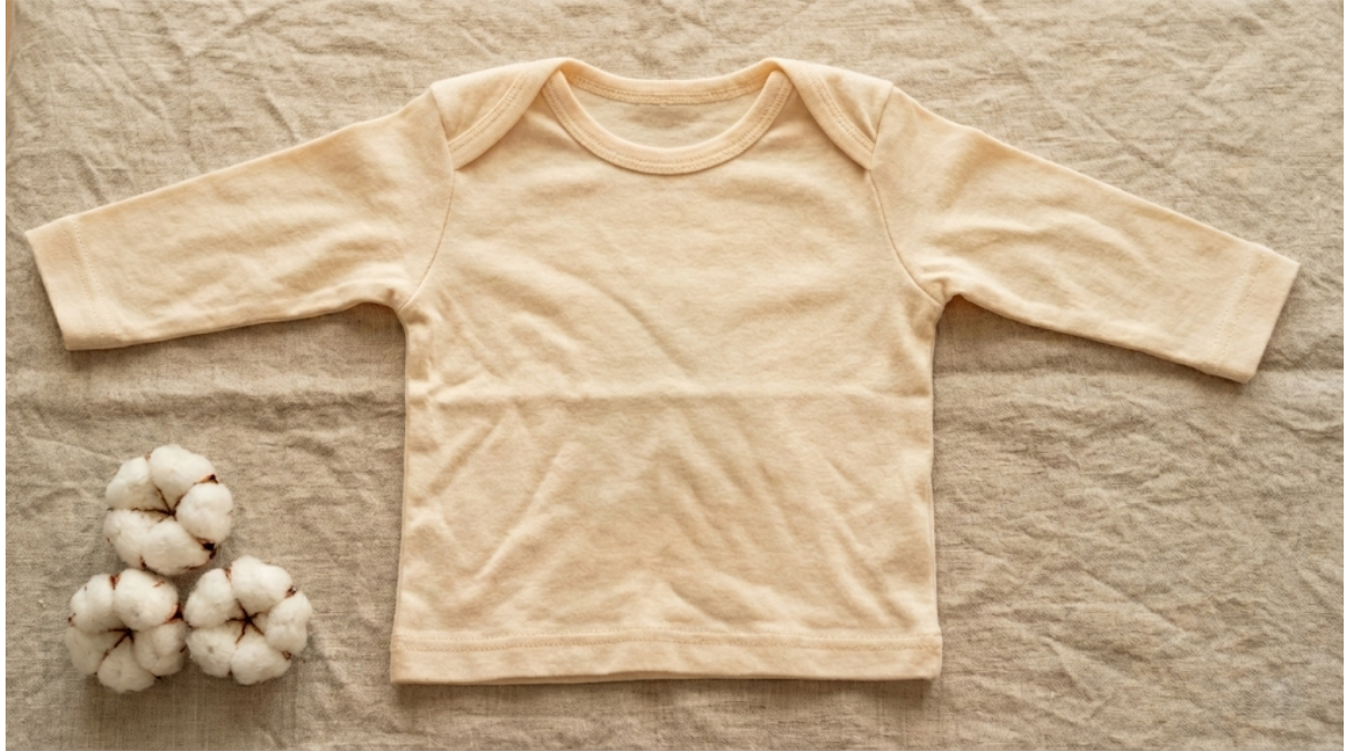 Soft organic cotton bolls alongside a Japanese-made baby garment