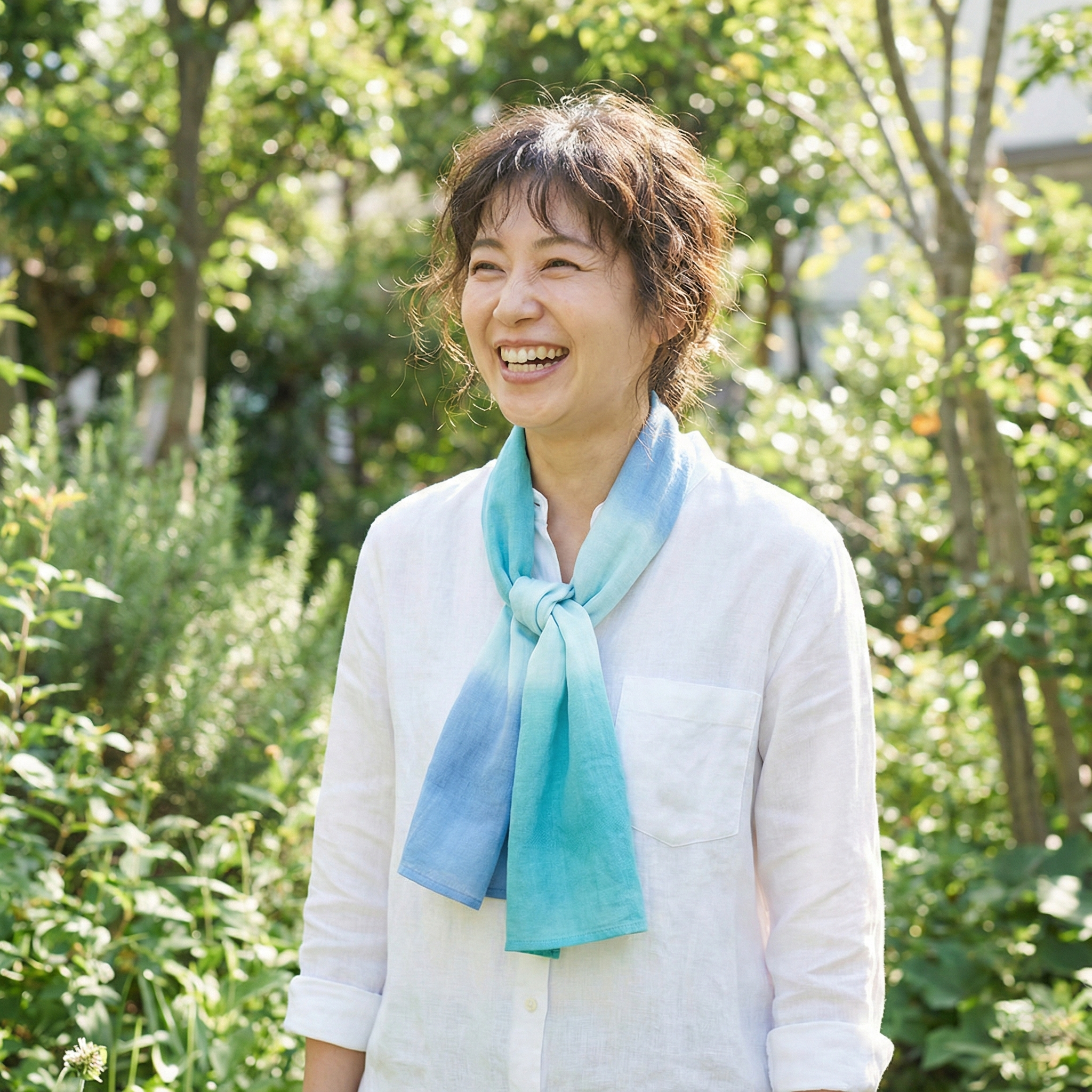 A woman wearing a chusen-dyed tenugui loosely around her neck as a summer scarf and sun protection