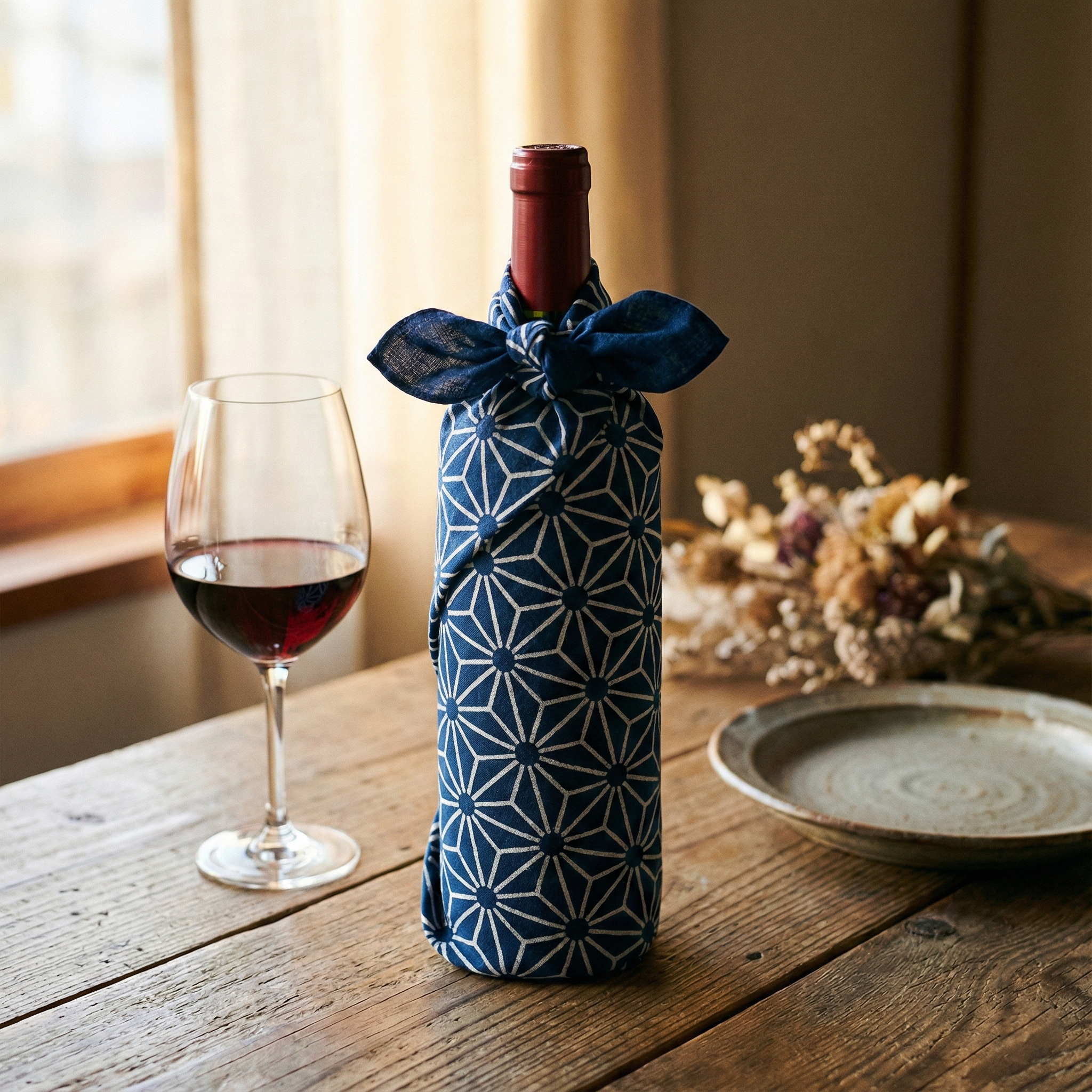 A wine bottle elegantly wrapped in a patterned tenugui, tied with a neat knot at the top