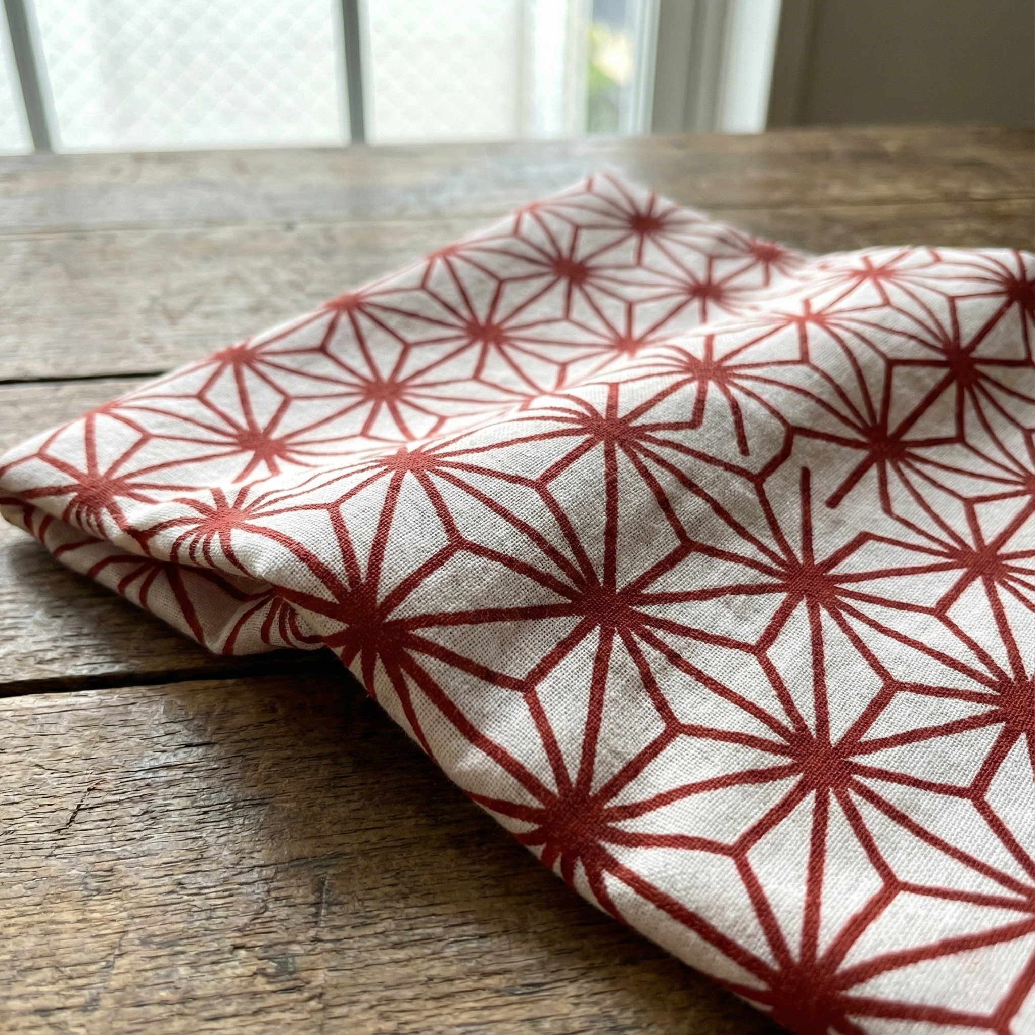 Tenugui with a traditional asanoha (hemp leaf) geometric pattern dyed in deep red