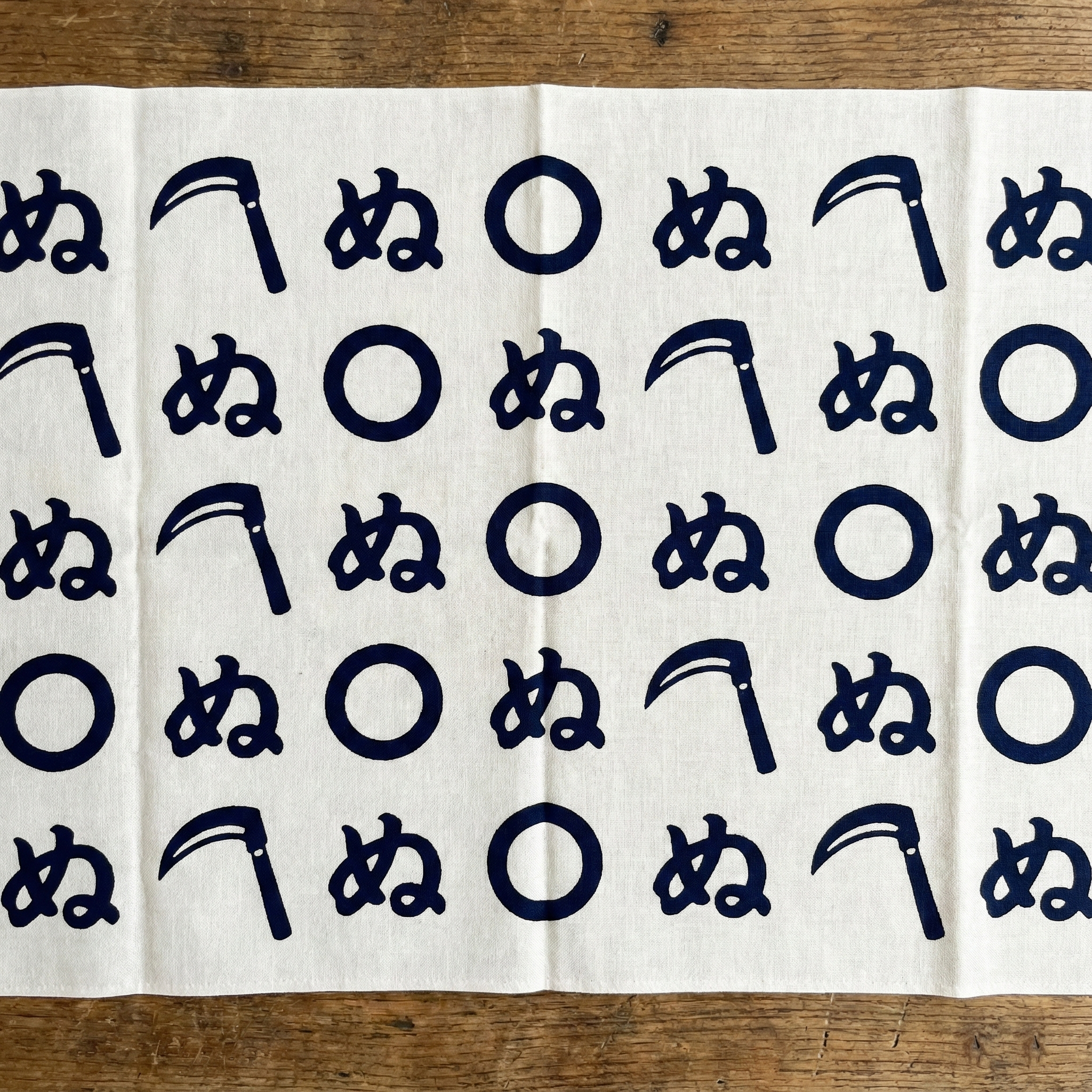 Tenugui with the kamawanu rebus pattern: a sickle, a circle, and the character 'nu' — an Edo-era visual pun